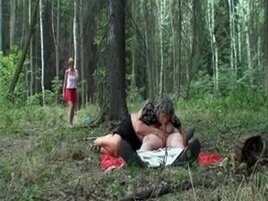 Old couple with a youthfull redhead in the forest