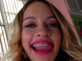 Blonde woman with braces is having fun with a big one